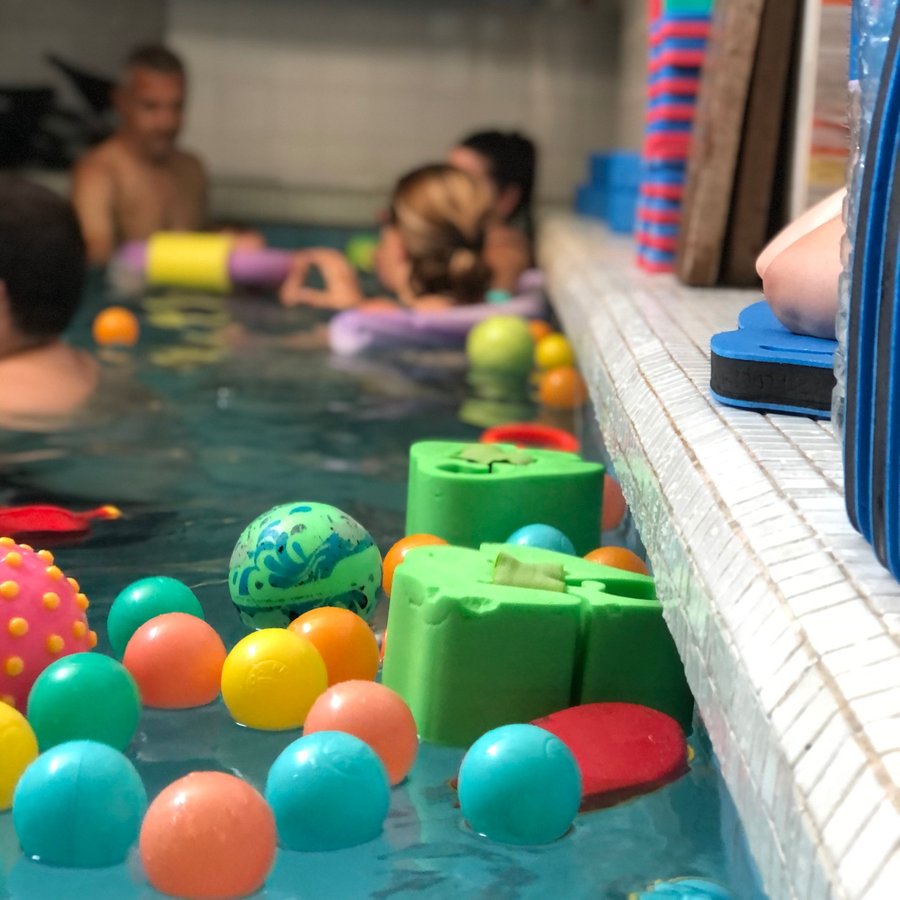 Balles et jouets colorés qui flottent dans le bassin pendant un cours